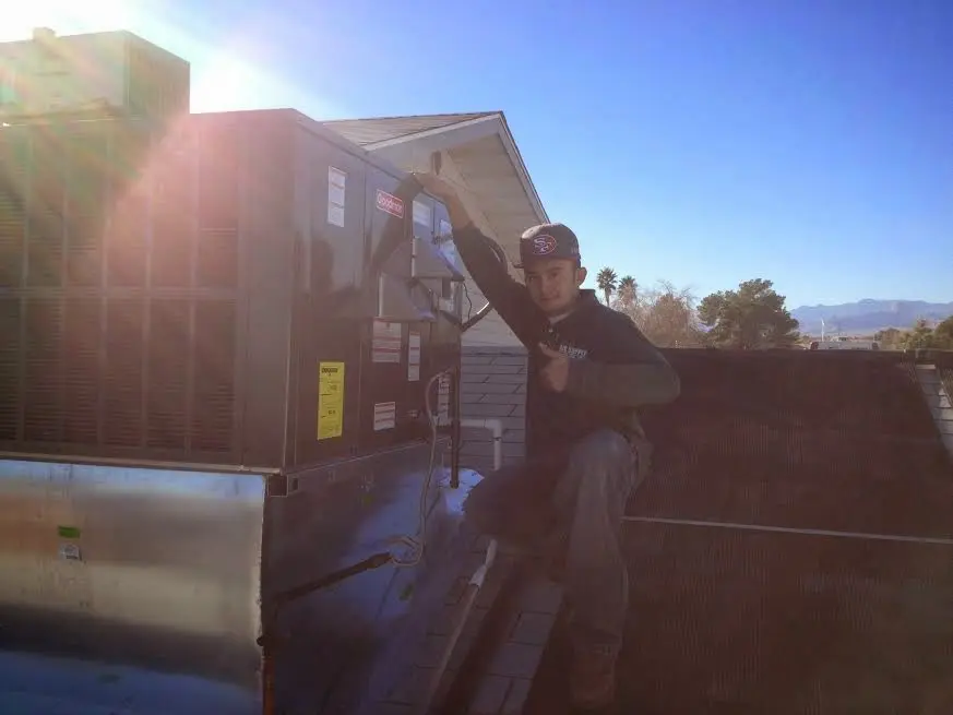 HVAC technician performing AC Tune-Up on a rooftop unit in Woodbridge